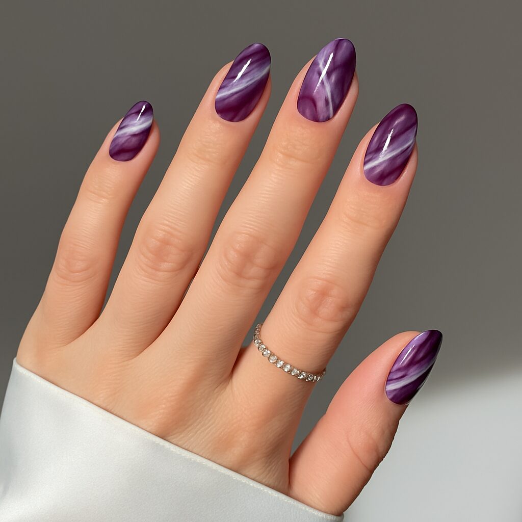 Dark purple marble nails with artistic white stone-like details.