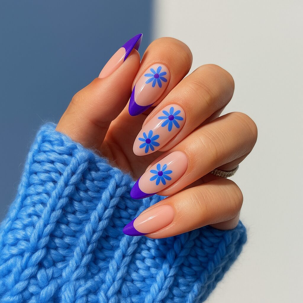 Eggplant French tips with floral purple and blue nail details.