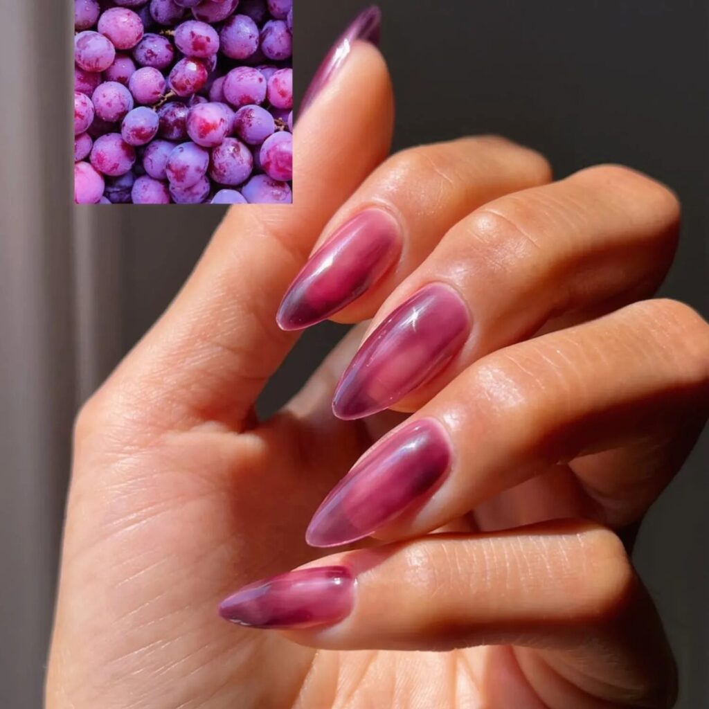 Close-up of real hands with glossy grape jelly nails in translucent purple polish, fall 2025 nail trend with shiny Y2K-inspired finish.
