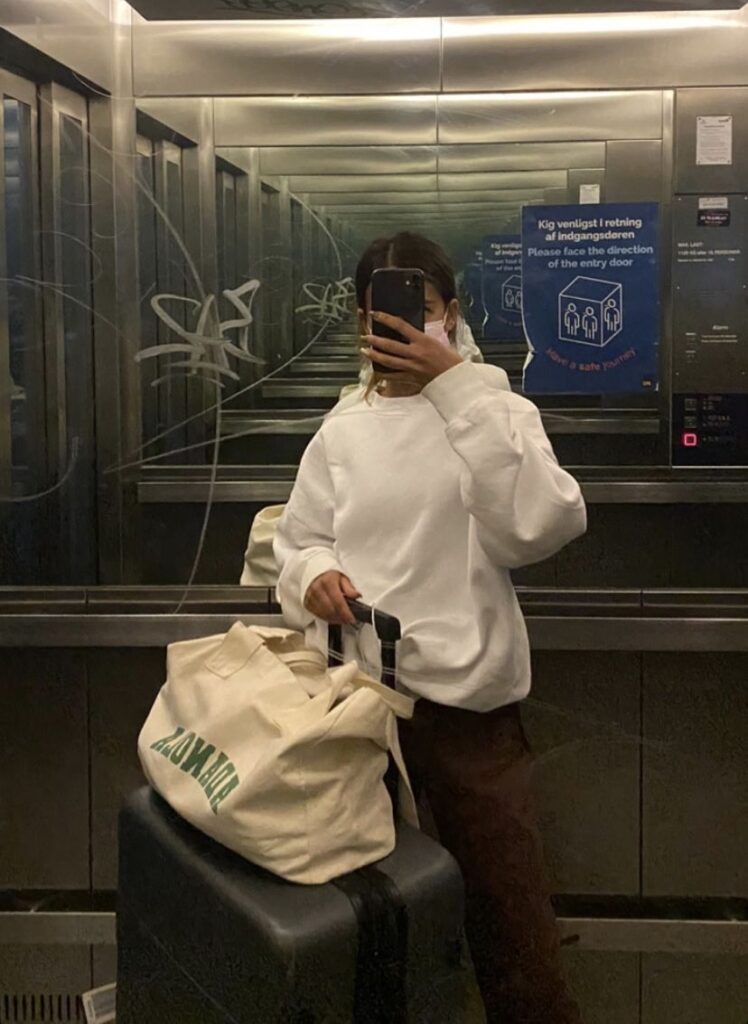 Casual pastel sweatsuit with clean white sneakers styled as chic travel outfit