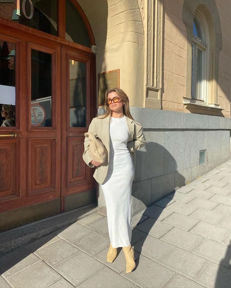 Airport outfit idea with a cotton midi dress and denim jacket draped over shoulders