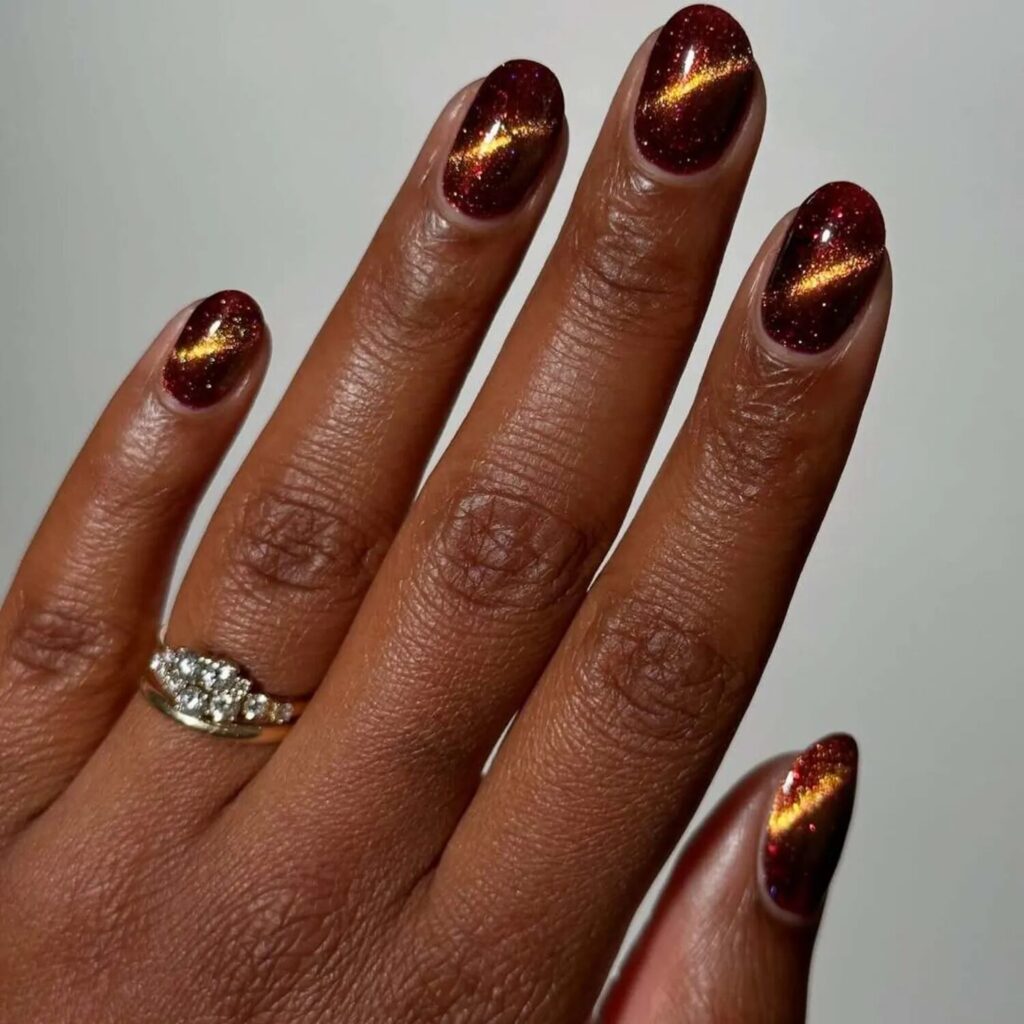 Short copper cat eye nails with shimmering dark polish perfect for October nail design