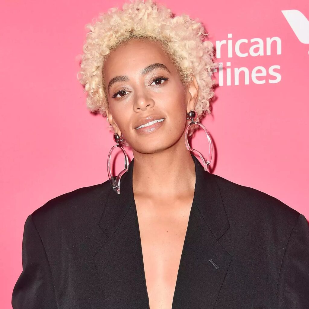 Solange Knowles with platinum blonde afro hairstyle styled in curls for a bold natural look