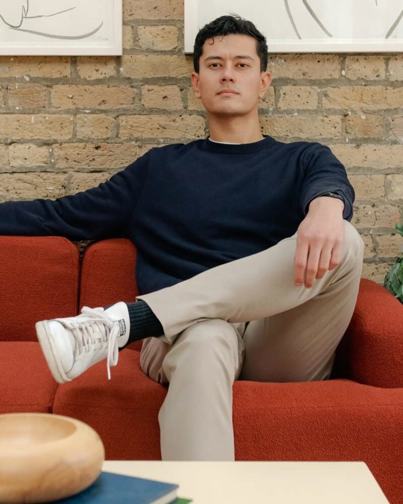 man layering grey sweatshirt under denim jacket with casual fall outfit