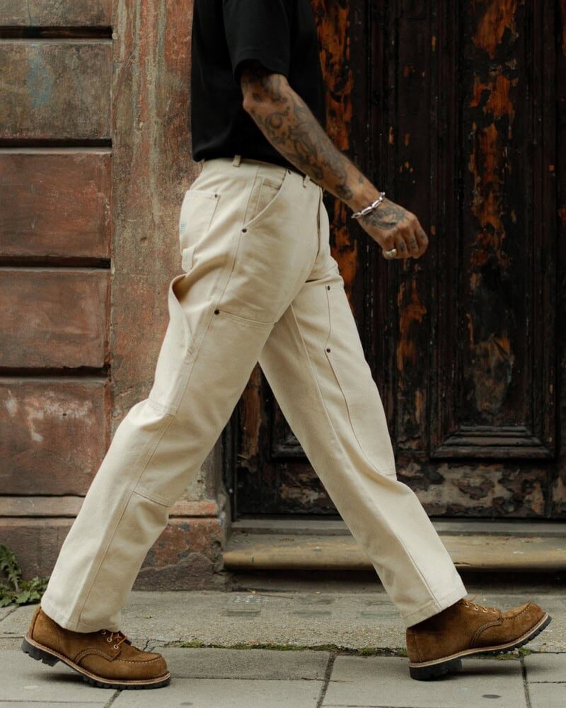 man in olive worker pants styled with plaid flannel shirt and brown boots