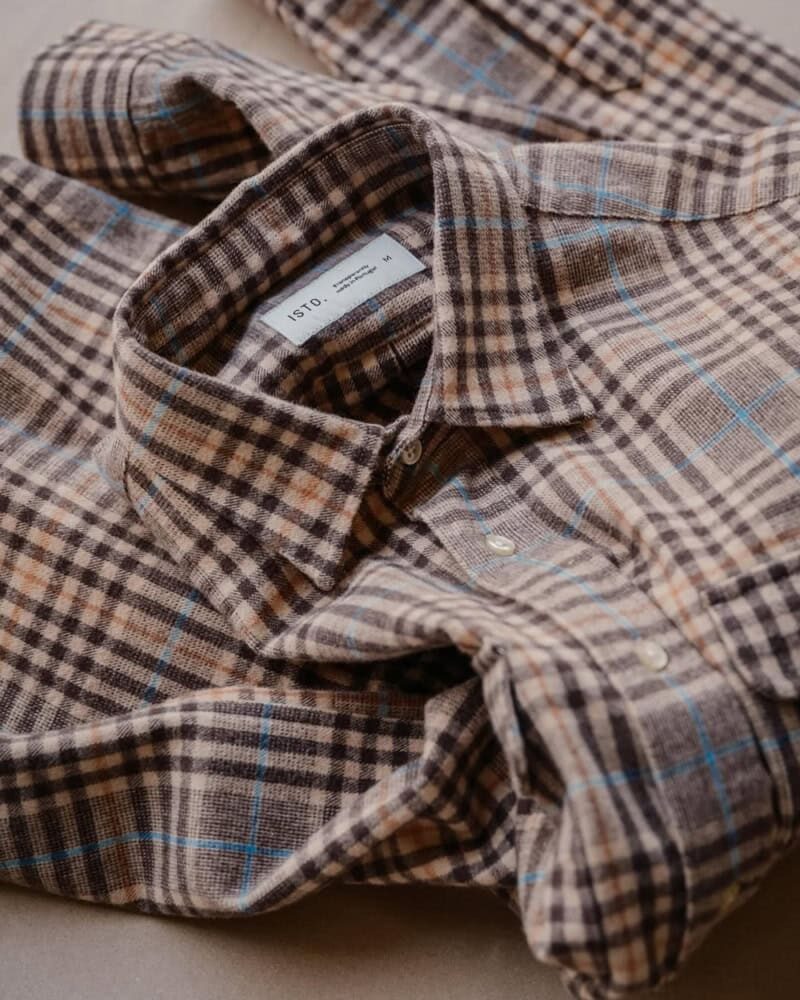 man wearing red plaid flannel shirt layered over white t-shirt in autumn outfit