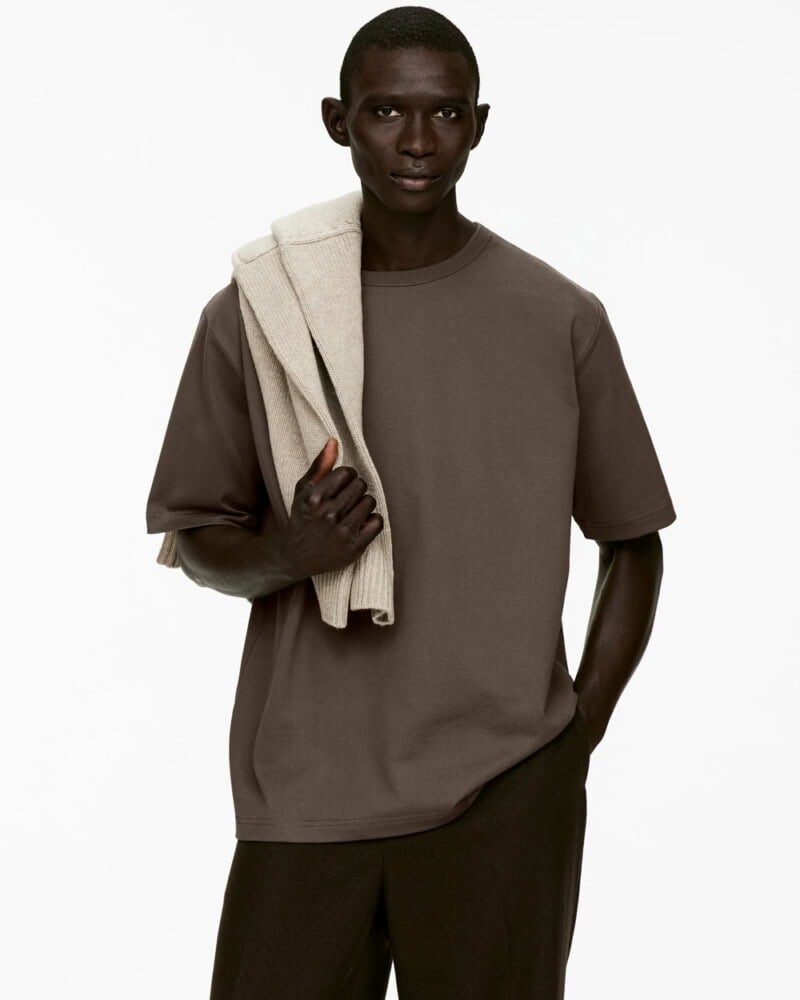 man wearing white heavyweight t-shirt tucked into black trousers with clean style