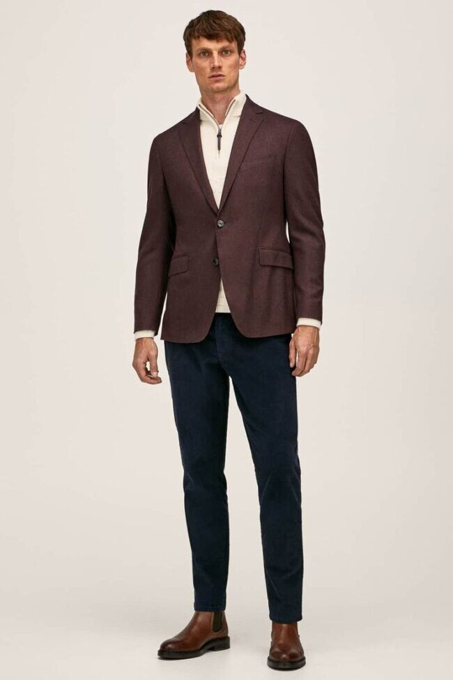 man in brick blazer and navy rollneck with dark trousers and suede shoes