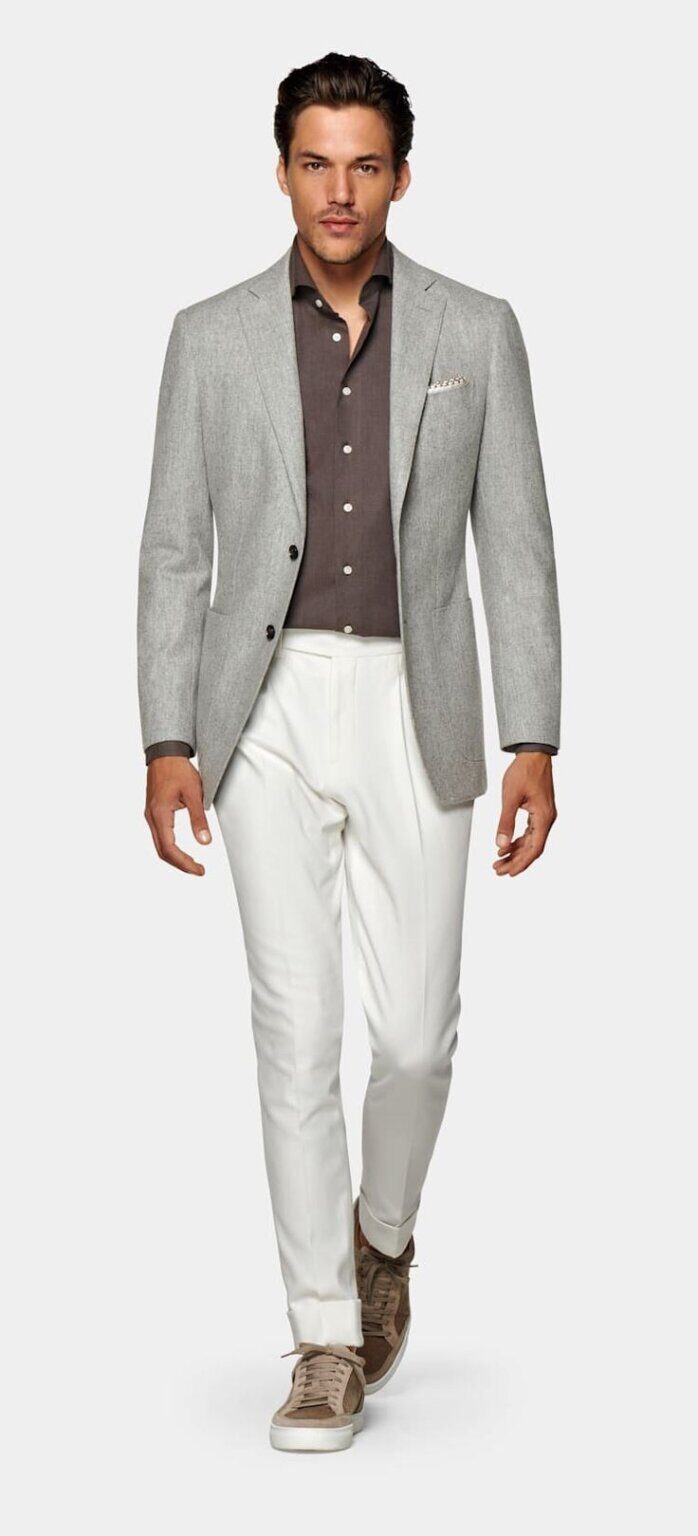 man in grey blazer and collared tee with white sneakers in smart casual office
