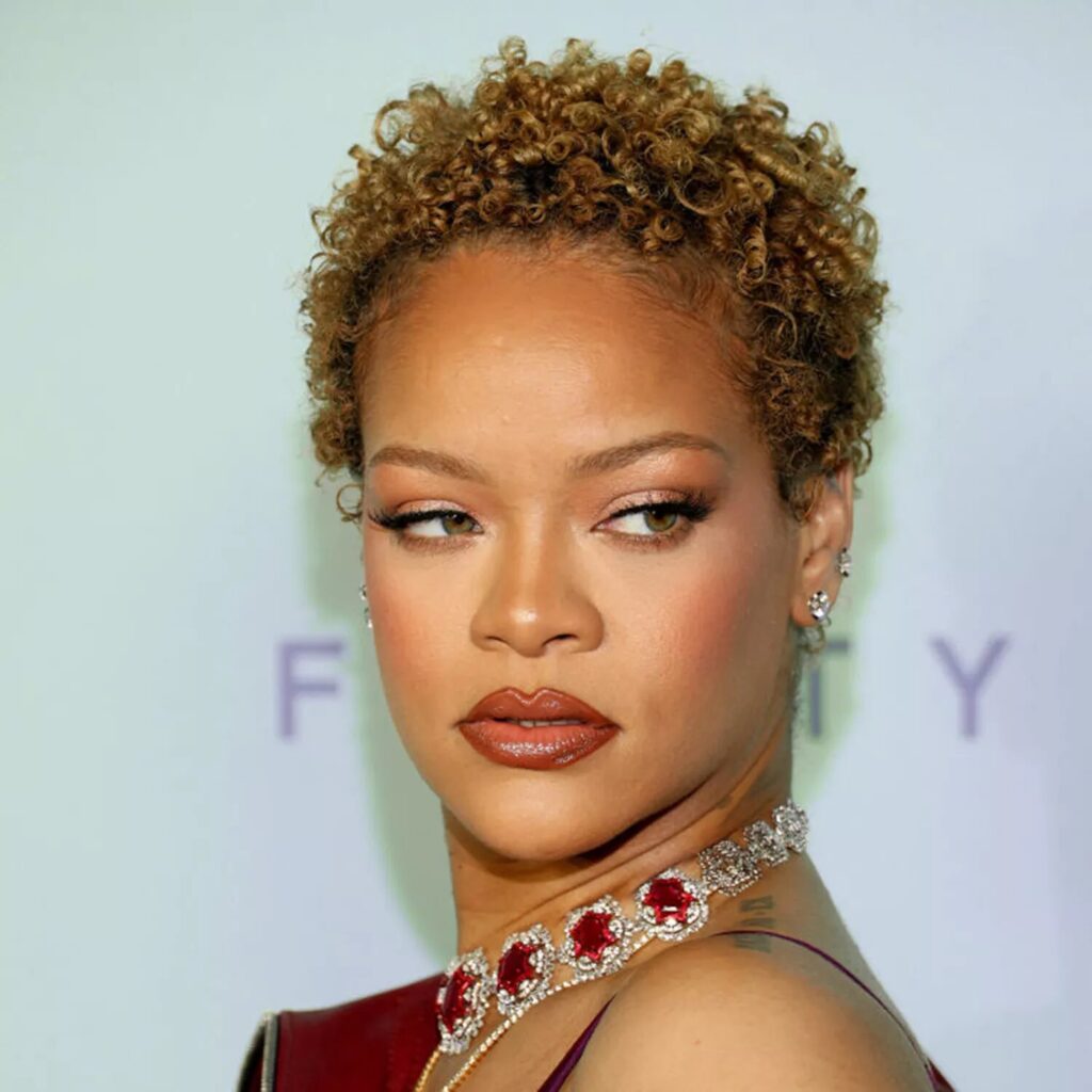 Rihanna styled in honey blonde finger coils creating a short curly afro wash and go look