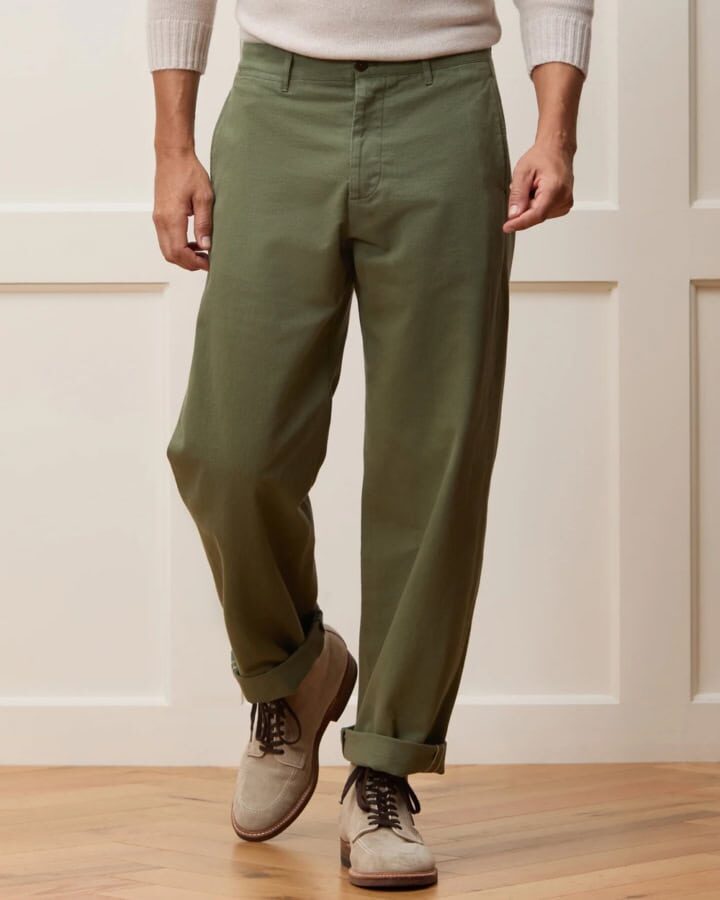 man wearing beige wide-leg chinos with sweater tucked in and white sneakers