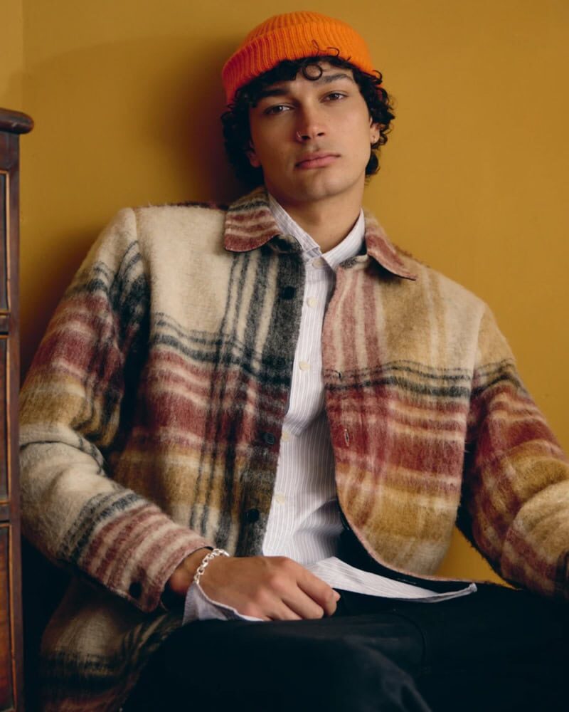 close-up of man wearing grey ribbed wool beanie in autumn city background