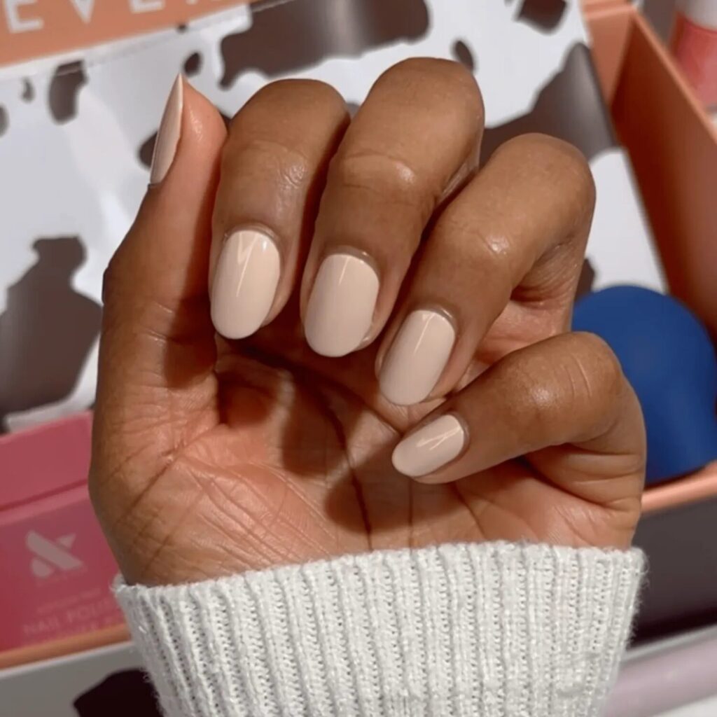 Short neutral nails in creamy polish with glossy top coat for a minimalist fall manicure