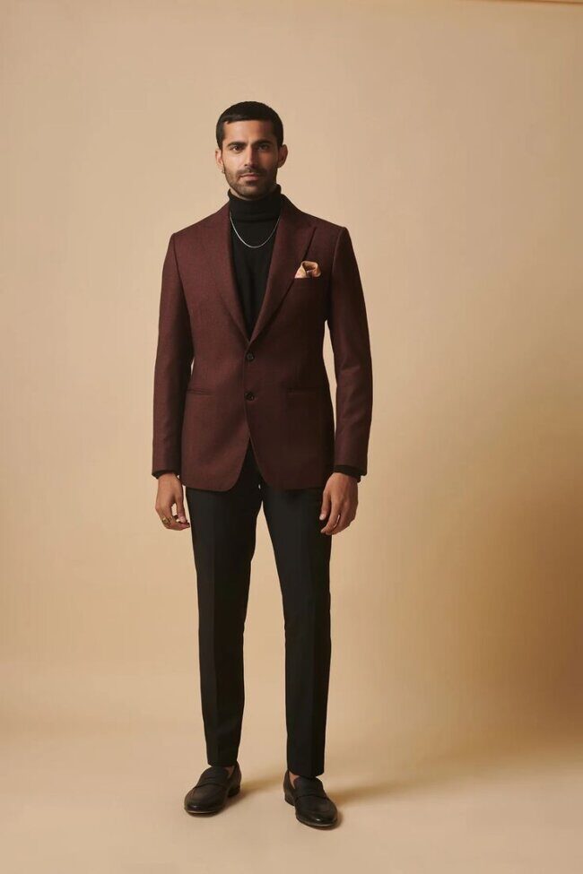 man in burgundy blazer and black turtleneck with dark trousers and loafers