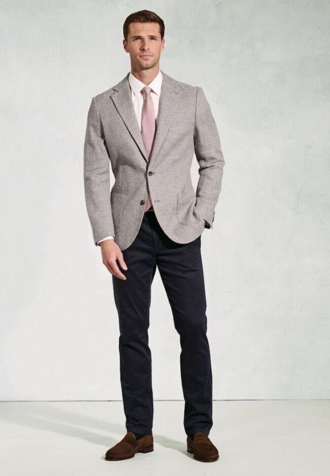 man wearing greige coat and beige trousers with tan tee and boots
