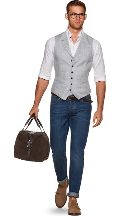 man in mocha vest and trench coat with tan trousers and boots