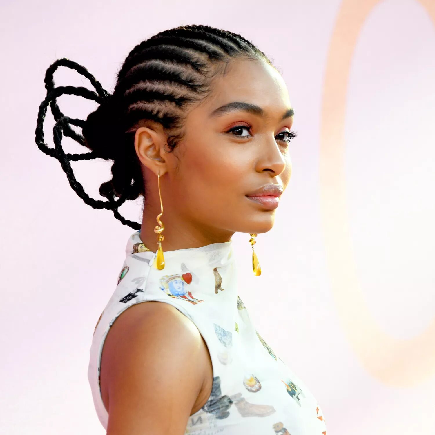 Sleek cornrows styled into a creative bun for a polished finish.