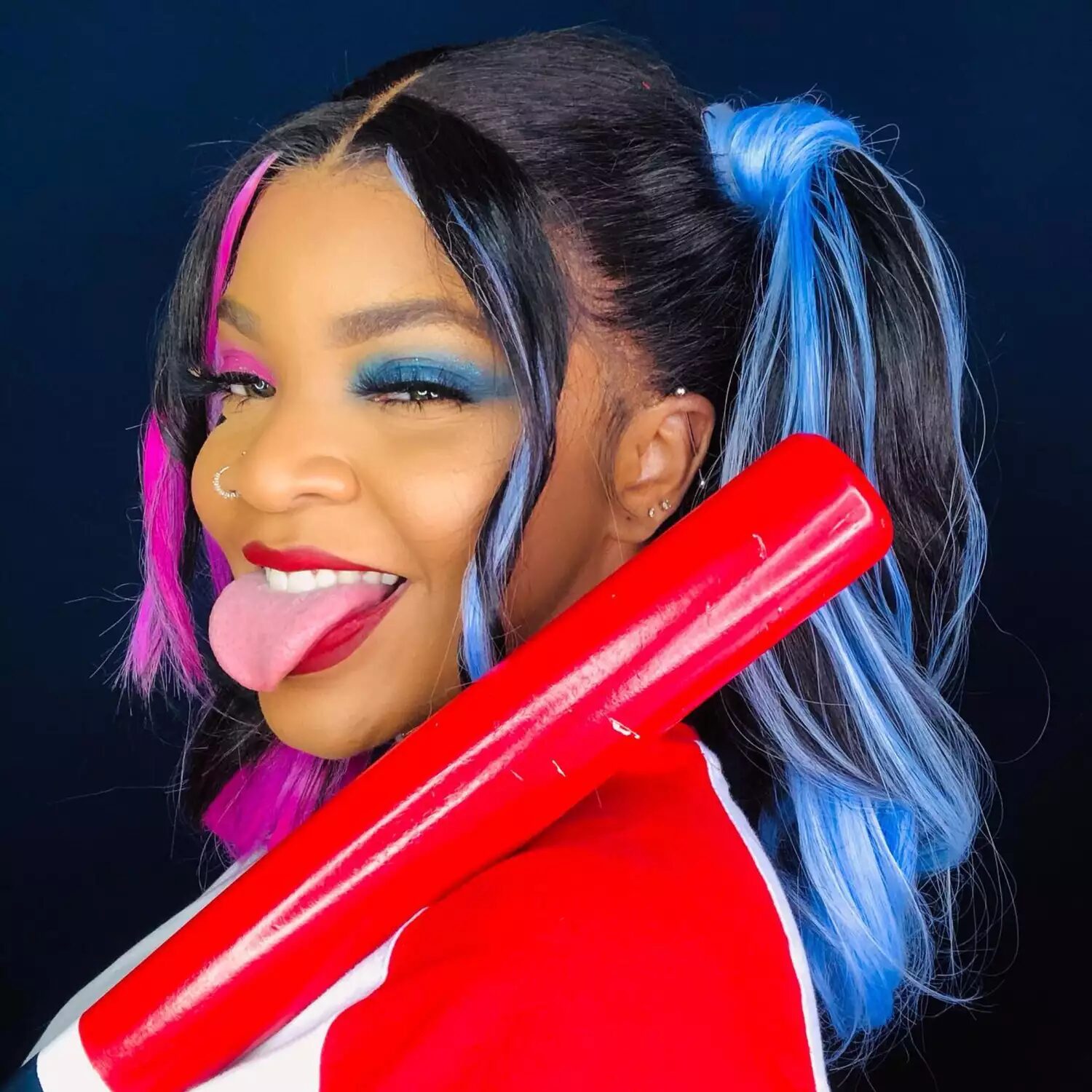 Harley Quinn Halloween hairstyle with high pigtails, pink and blue streaks, two-tone hair inspired by Margot Robbie.