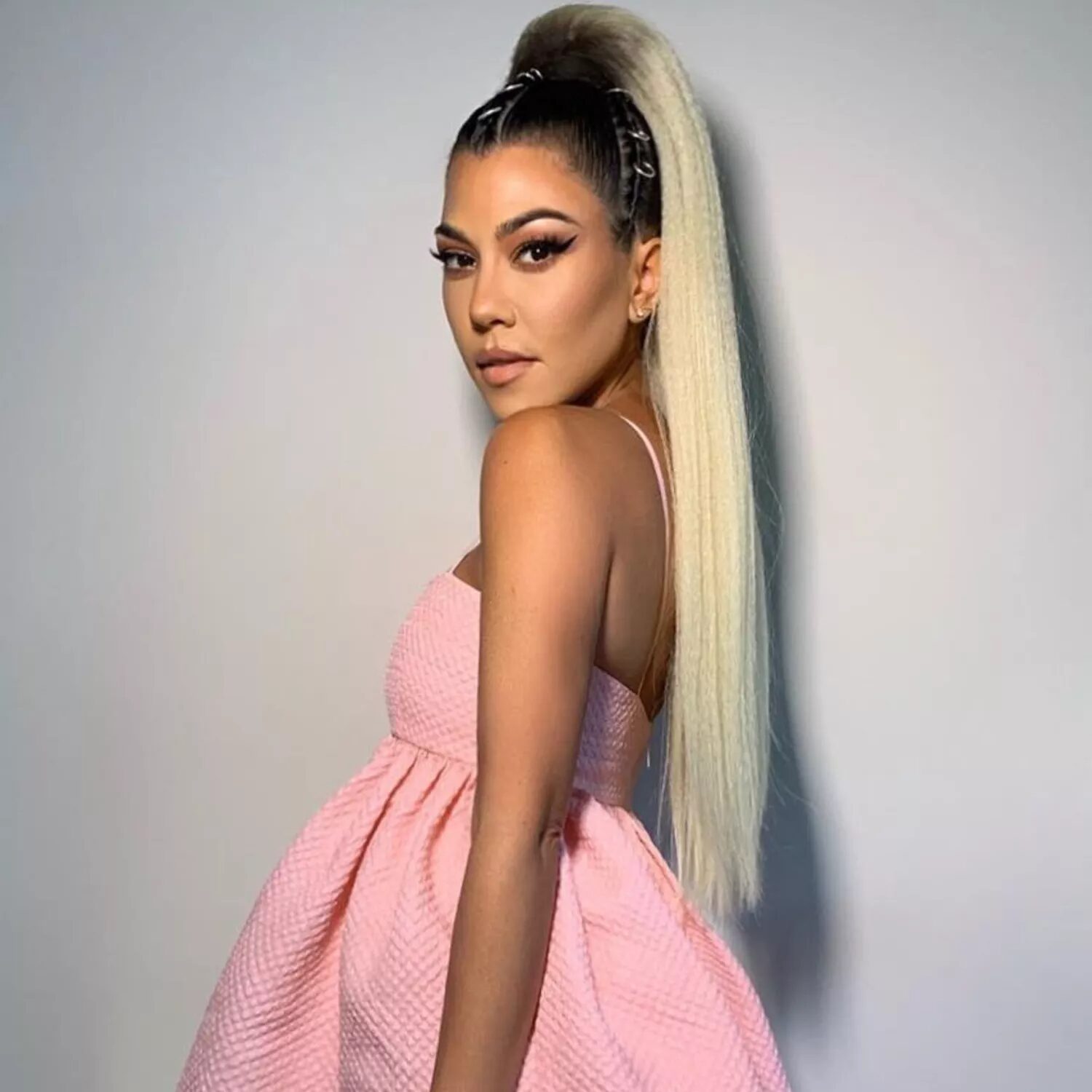 Ariana Grande-inspired Halloween hairstyle featuring sleek high ponytail, glossy hair, and pink outfit.