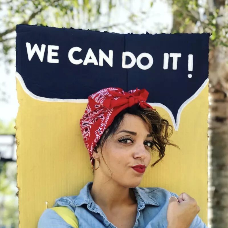 Rosie the Riveter Halloween hairstyle with red bandana, messy bun, and classic 1940s inspired empowerment look.