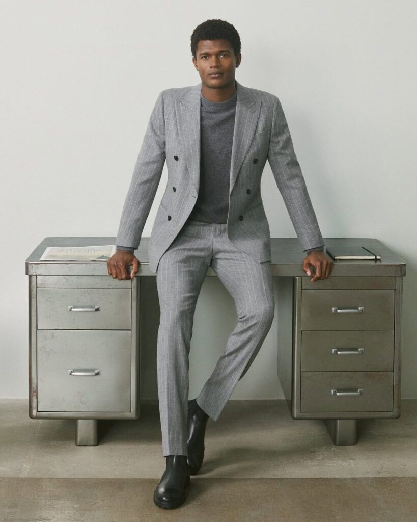 Model in slim fit Reiss gray travel suit with tailored blazer and loafers, representing modern London menswear style.