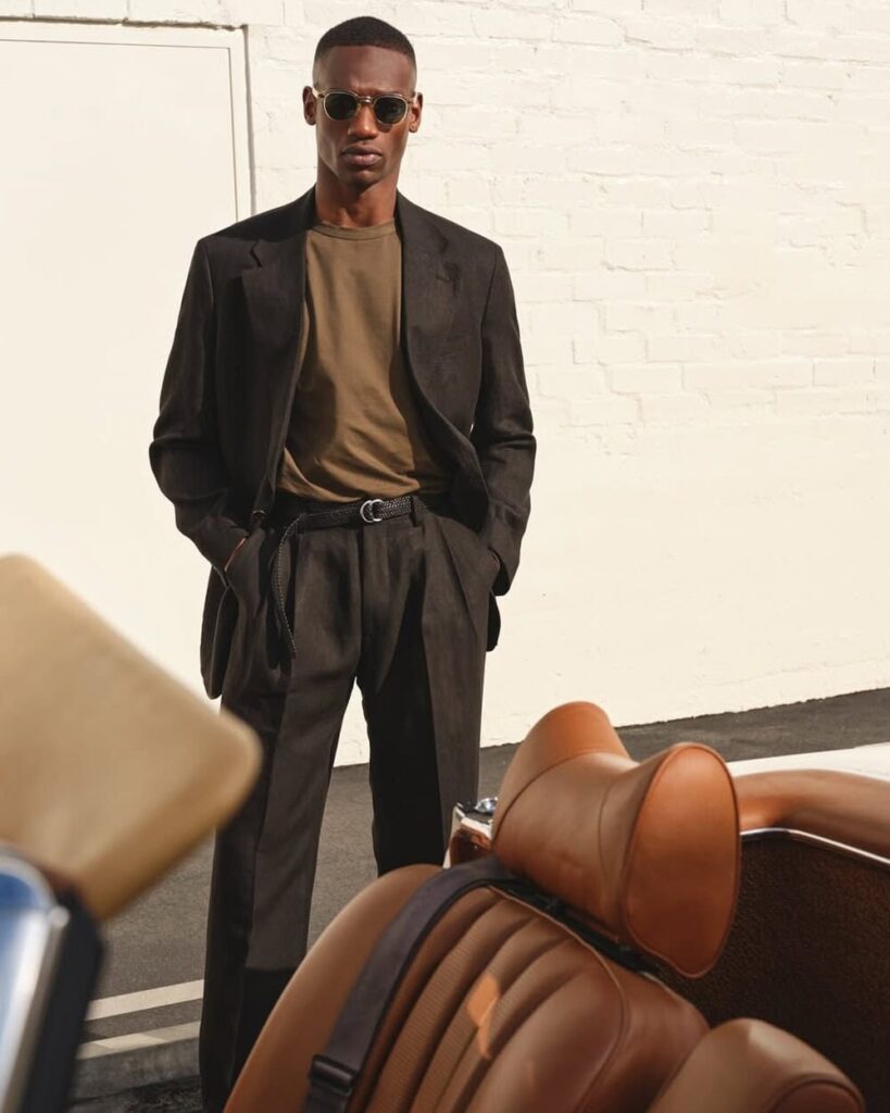 Man wearing Todd Snyder tropical wool suit in beige with open collar shirt, showing relaxed American tailoring.
