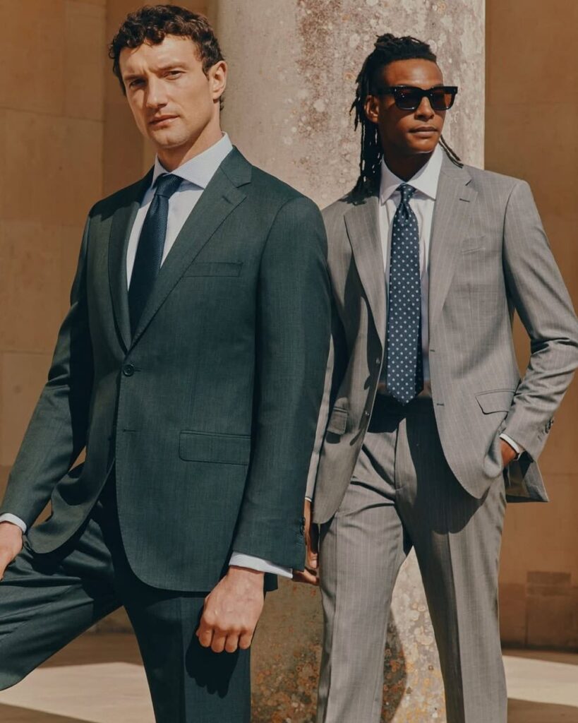 Gentleman in Hawes & Curtis navy chalk stripe wool suit with classic shirt and tie, representing timeless British tailoring.