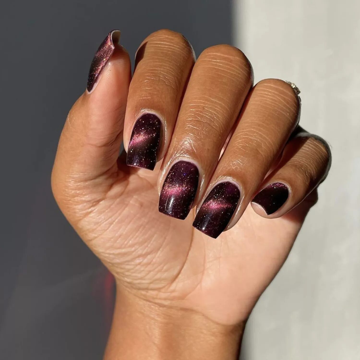 Moody burgundy manicure with soft shimmer finish for elegant and subtle fall nail inspiration.