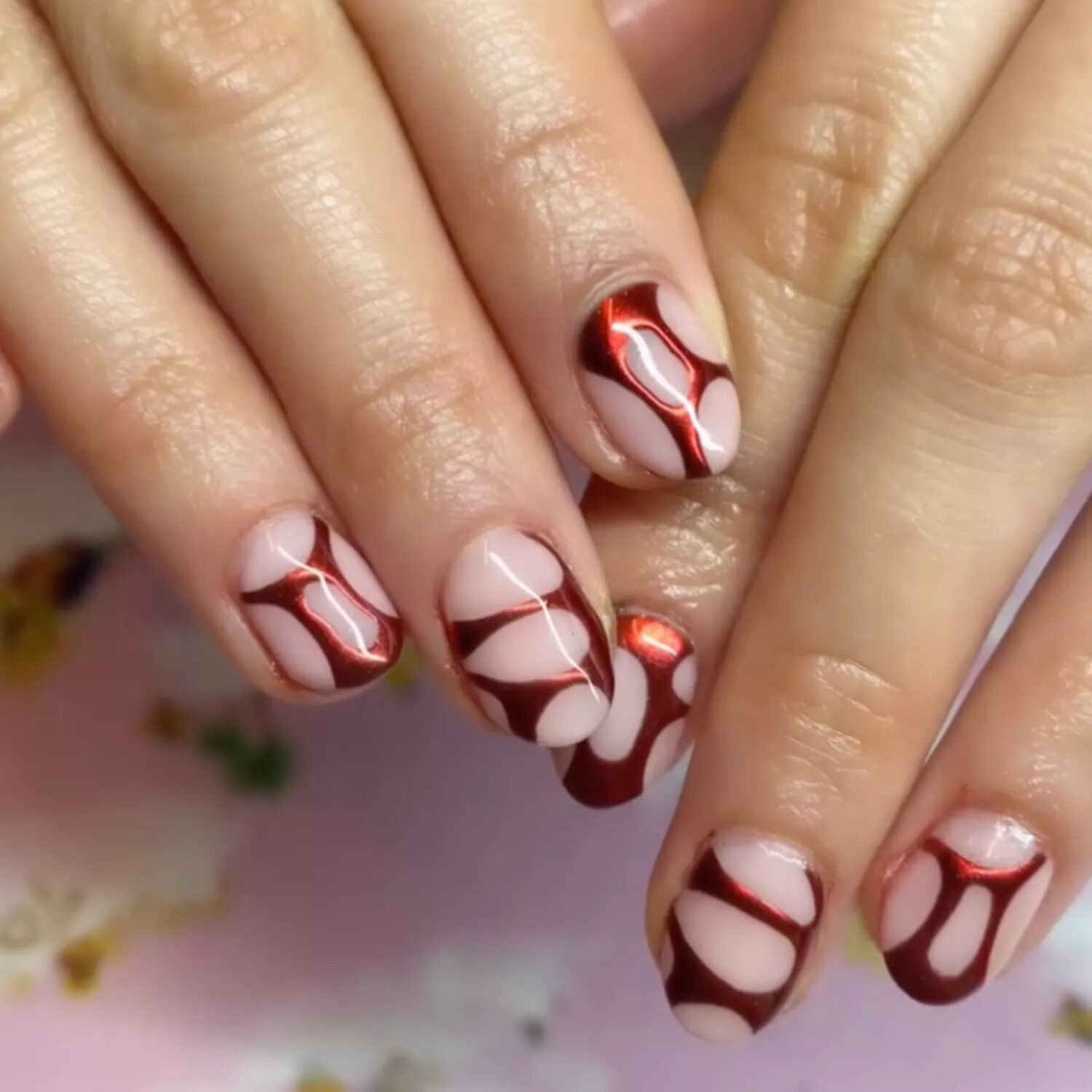 Chrome burgundy nails with web-like metallic art design for a futuristic high-shine manicure.