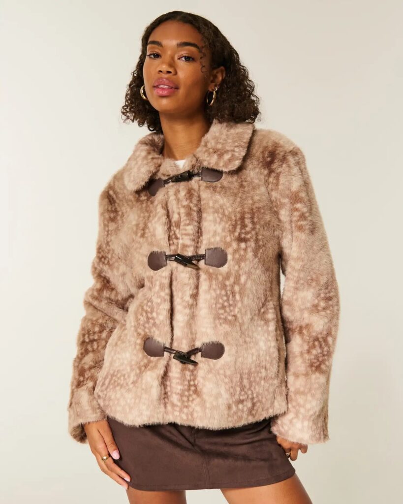 Street style outfit featuring fawn-print jacket, suede boots, and neutral-toned accessories for fall.