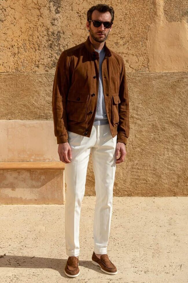man wearing sand jacket over henley shirt with light khakis