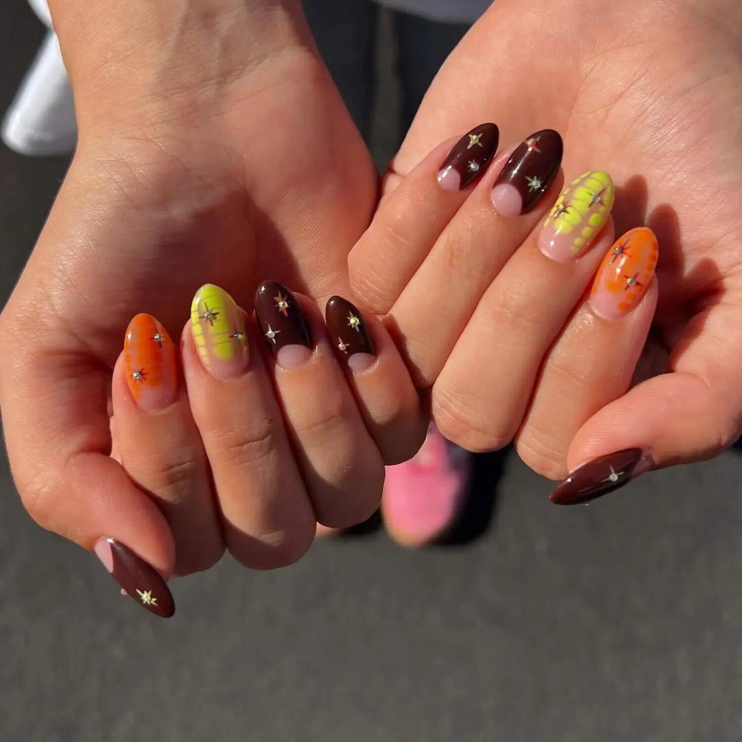 Candy corn-inspired nails with orange, yellow, and brown chrome tones