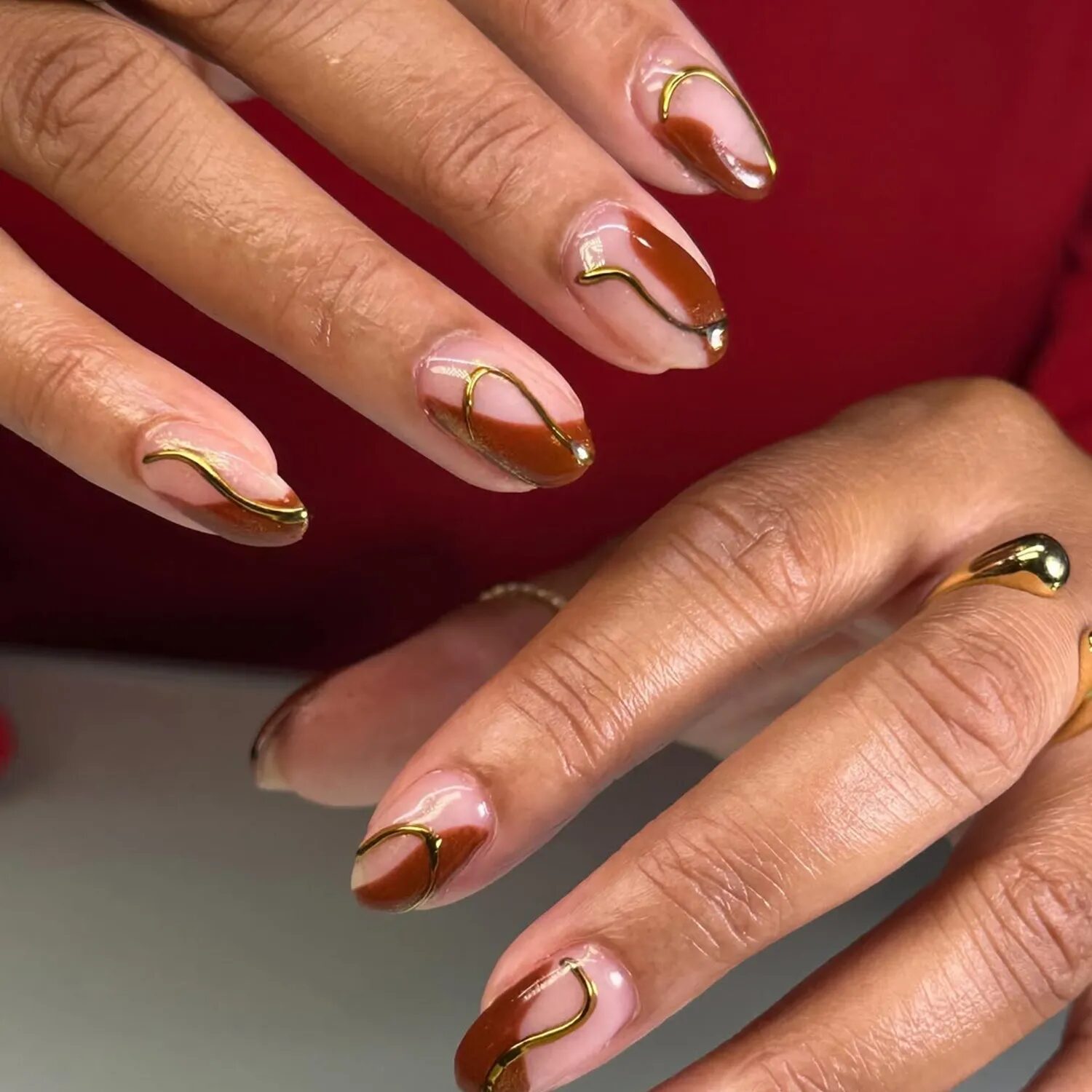 Chocolate brown and gold swirl chrome manicure with gold rings
