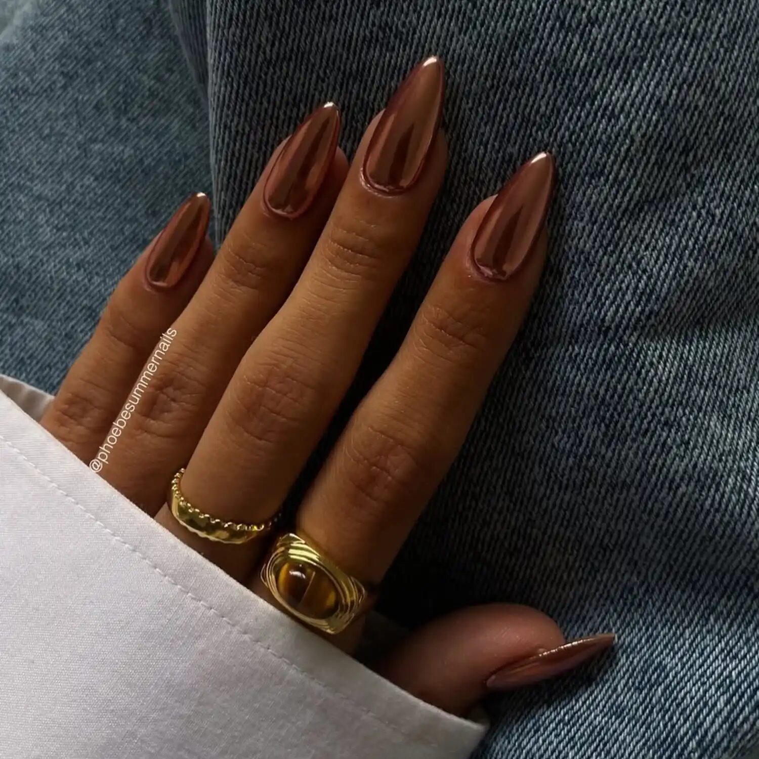 Almond-shaped chocolate chrome nails with glossy reflection