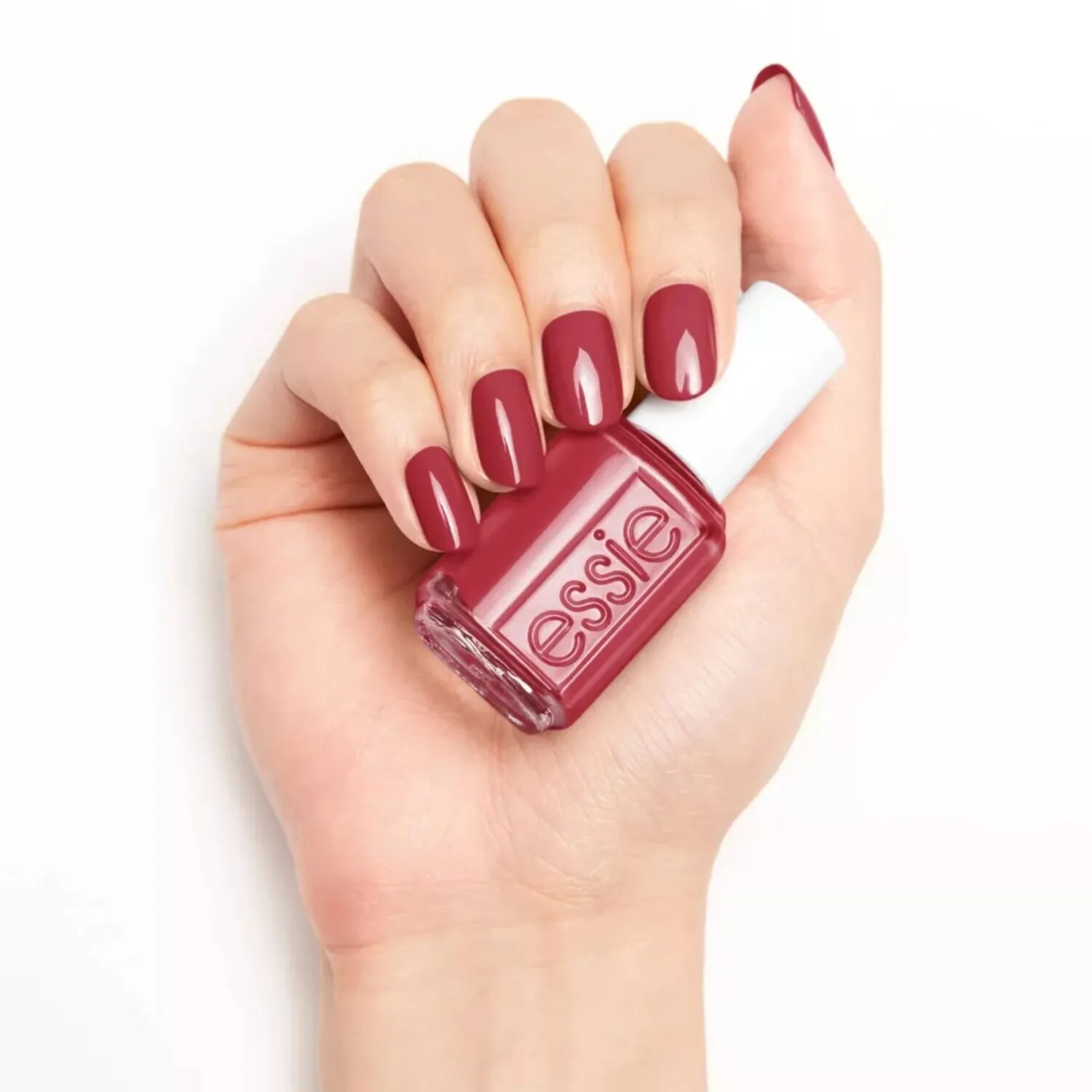 Close-up of hands showing muted dusty red nails with warm undertones