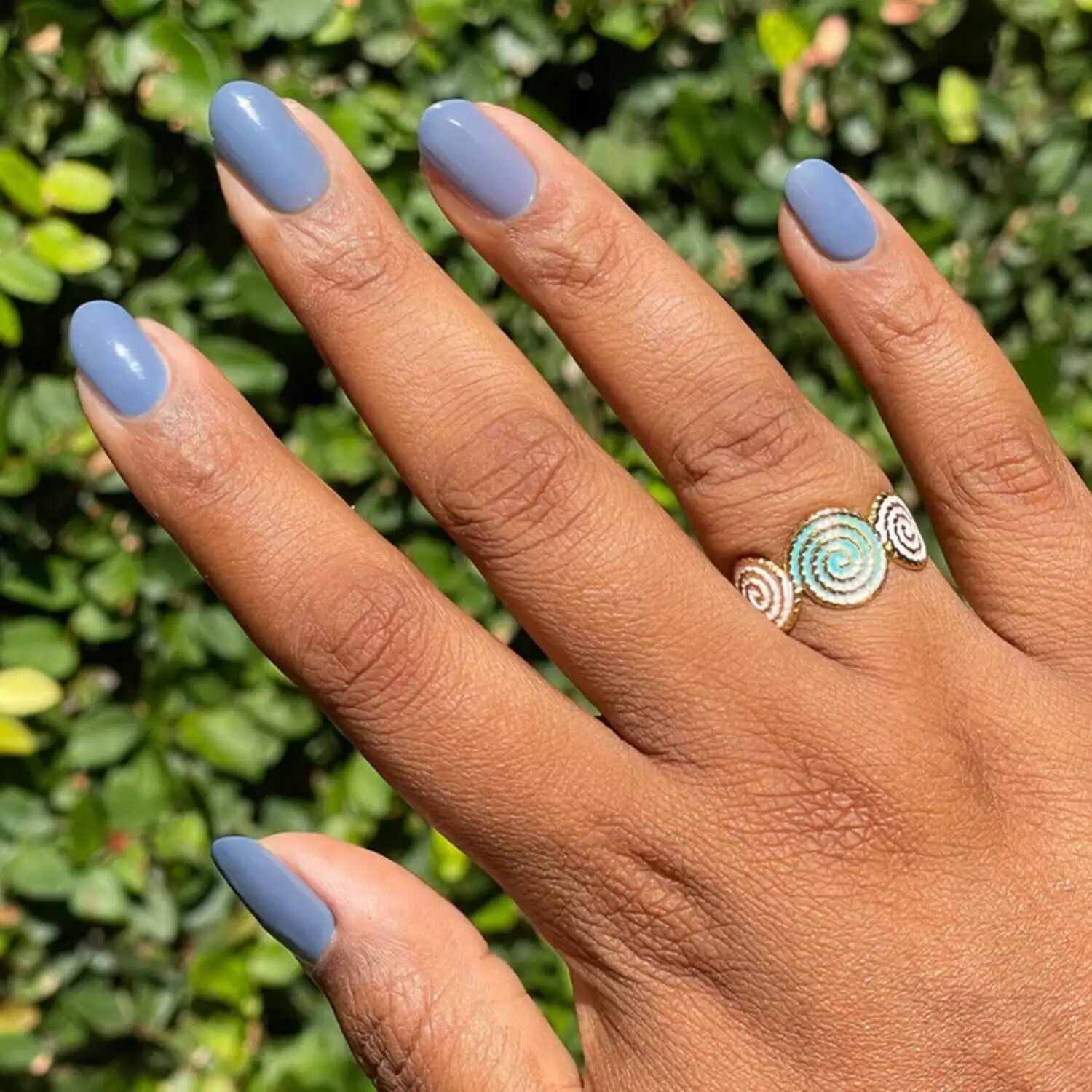 Short nails in cool slate blue polish echoing October’s moody sky tone