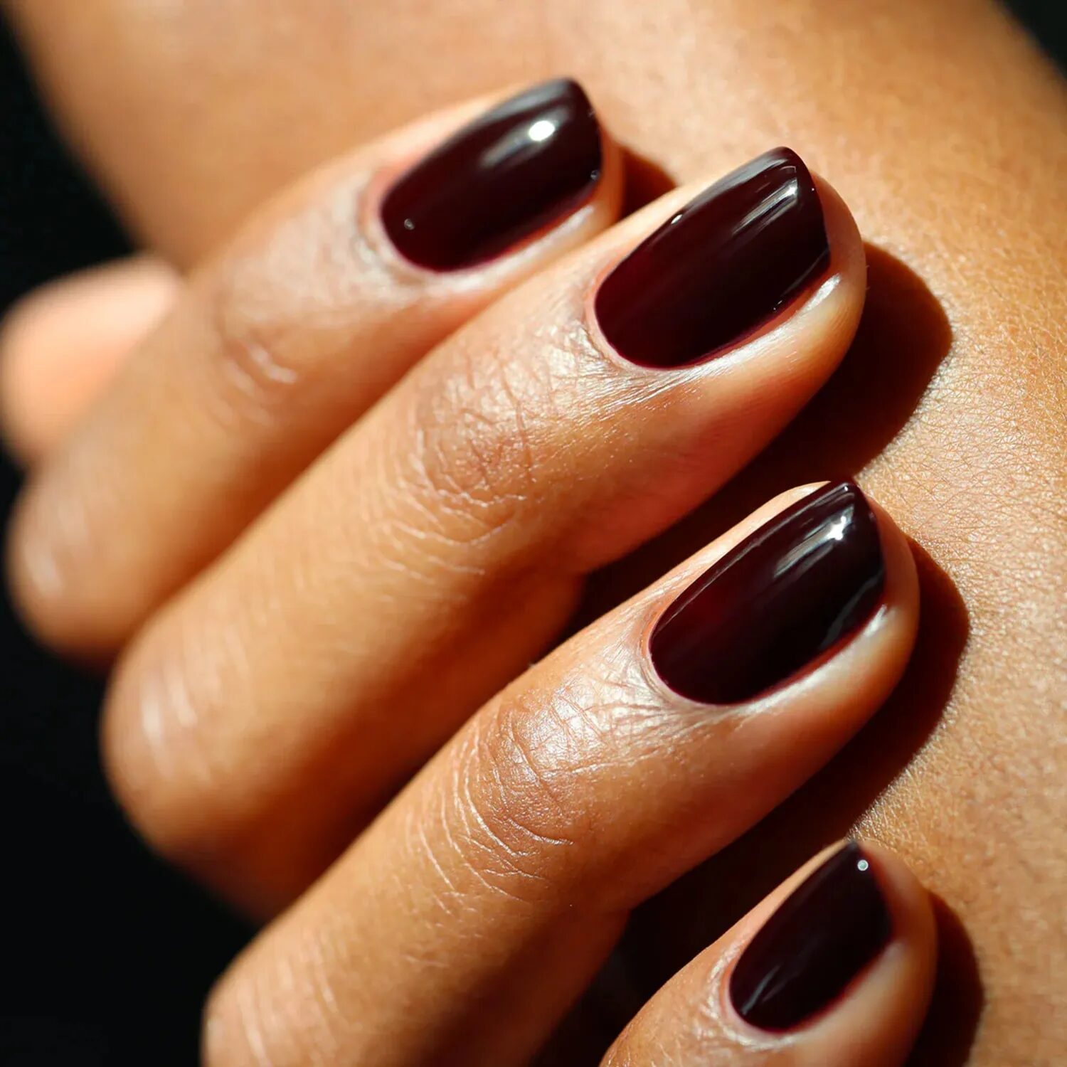 Nails in rich maroon-brown tone blending burgundy and chocolate hues