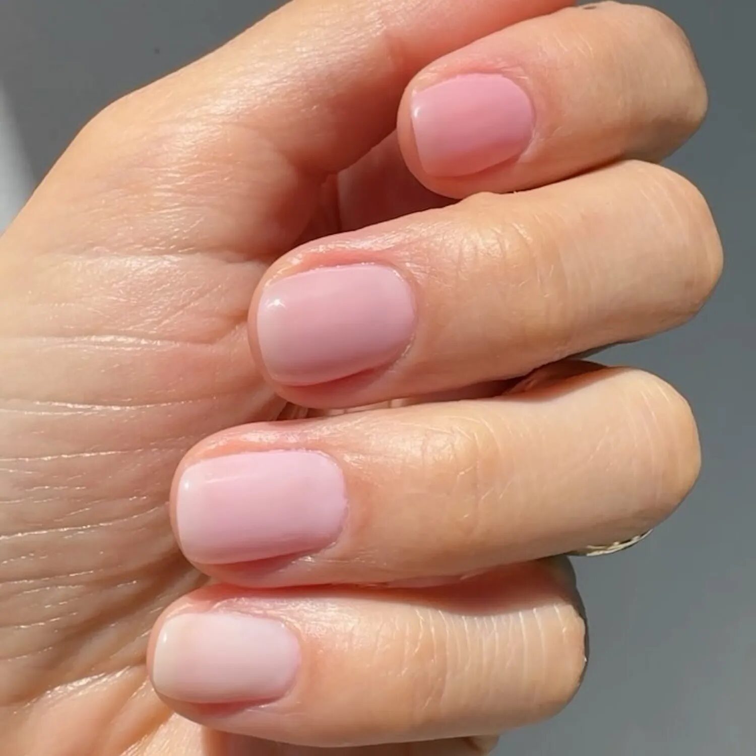 Minimal nails with pale pink waxy neutral finish for a soft elegant look