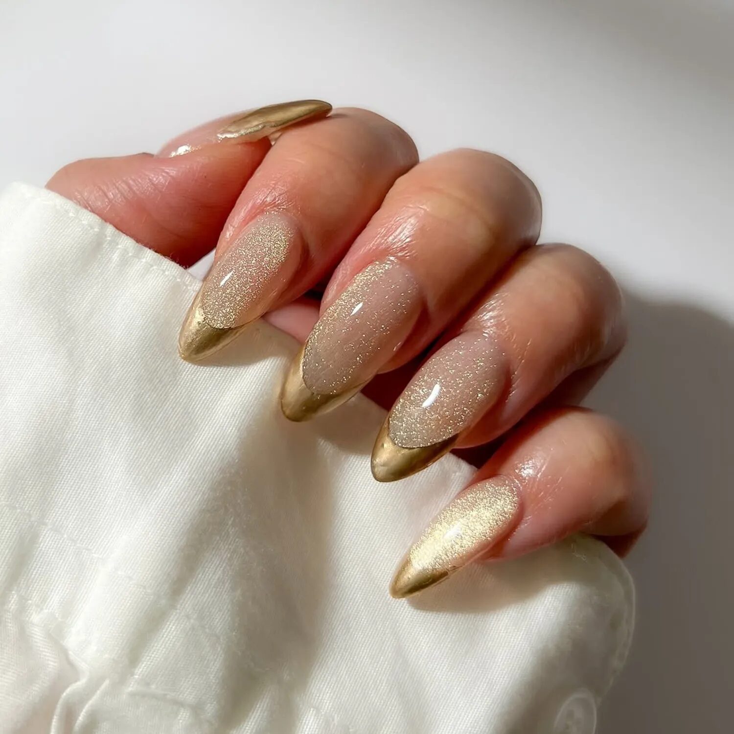 Neutral champagne velvet French nails with gold shimmer tips and classy soft-glow finish.