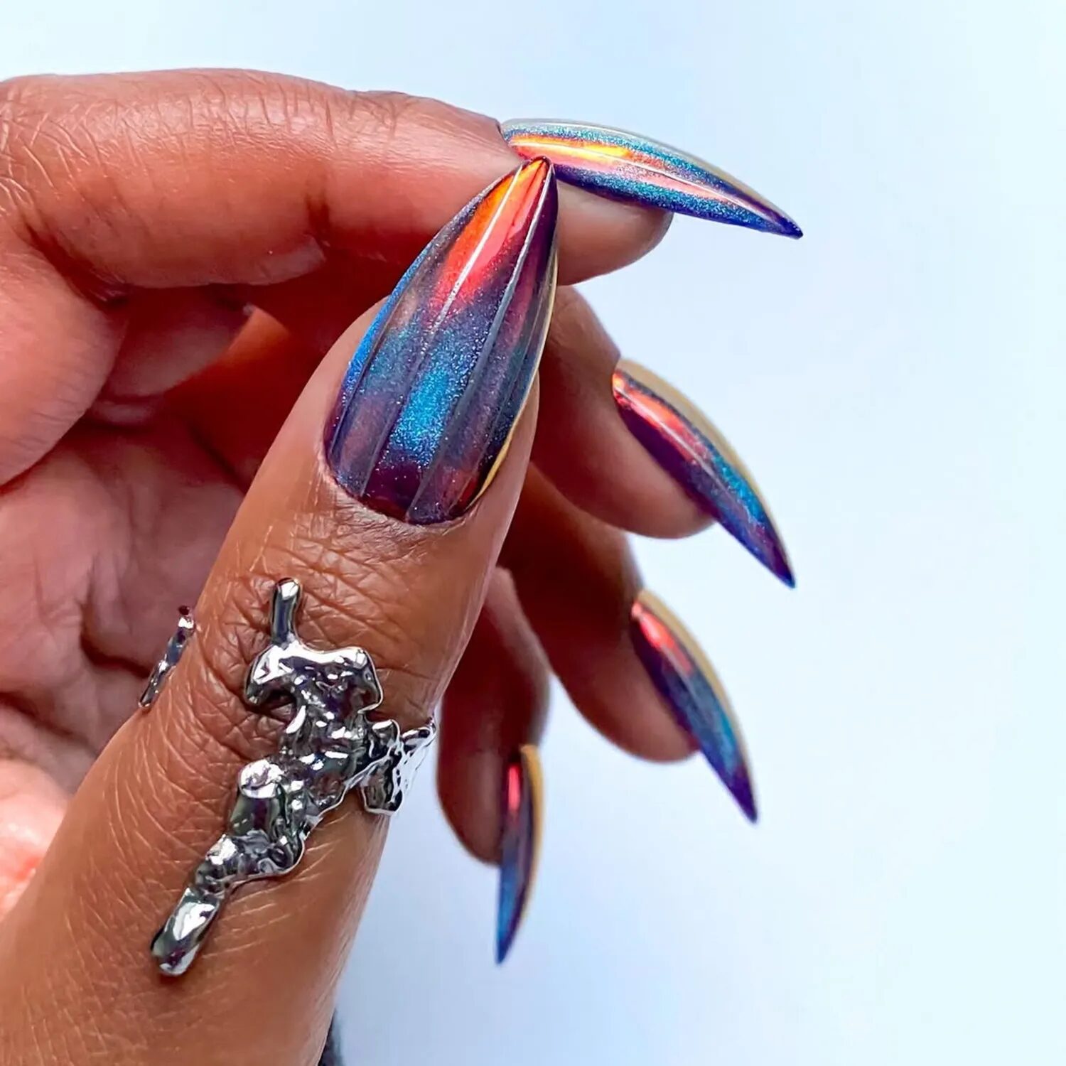 Multichrome metallic velvet nails with bold color-shifting shimmer and disco-party look.
