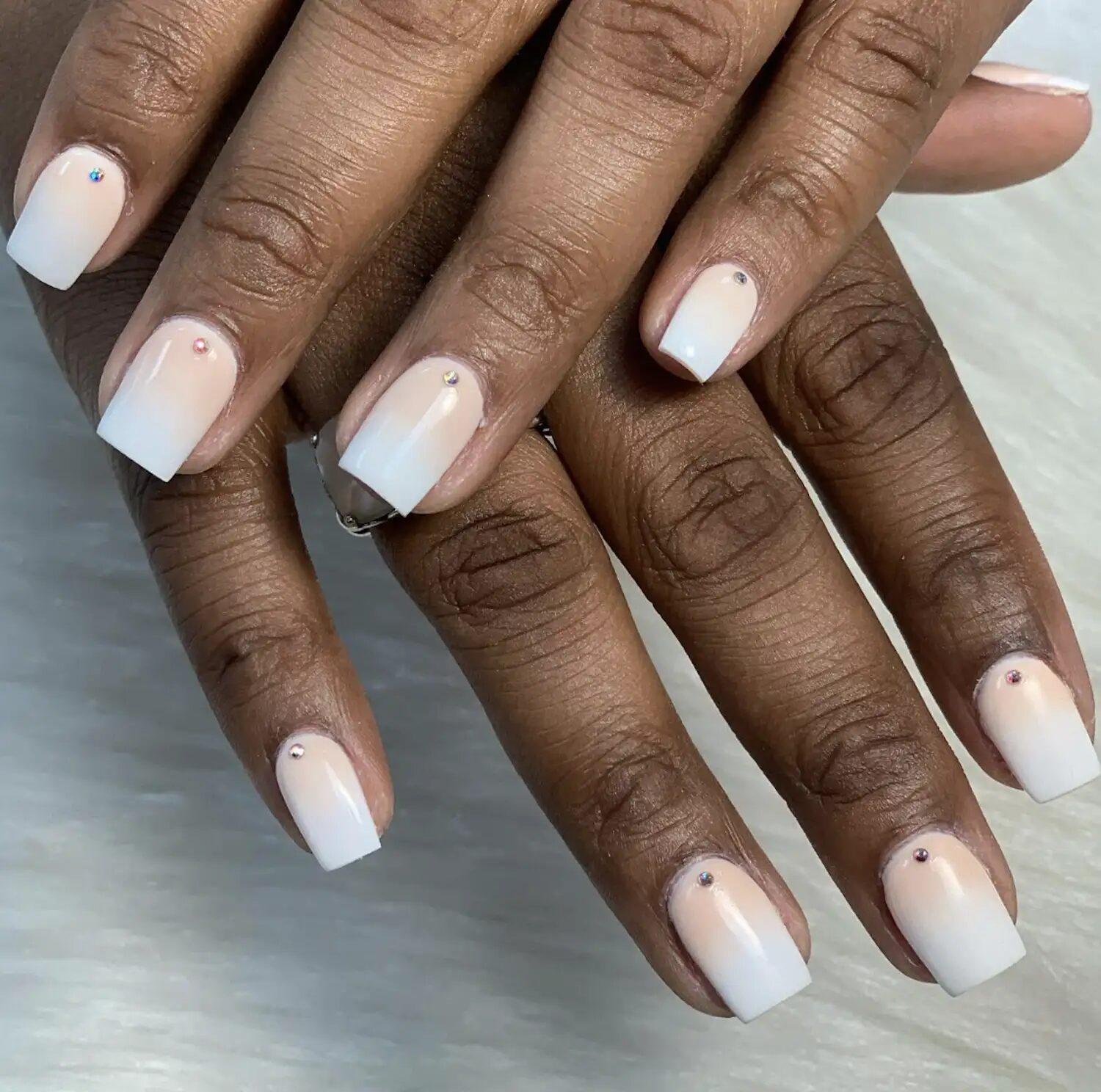 Close-up of long-lasting dip powder manicure with glossy finish and soft nude tone.