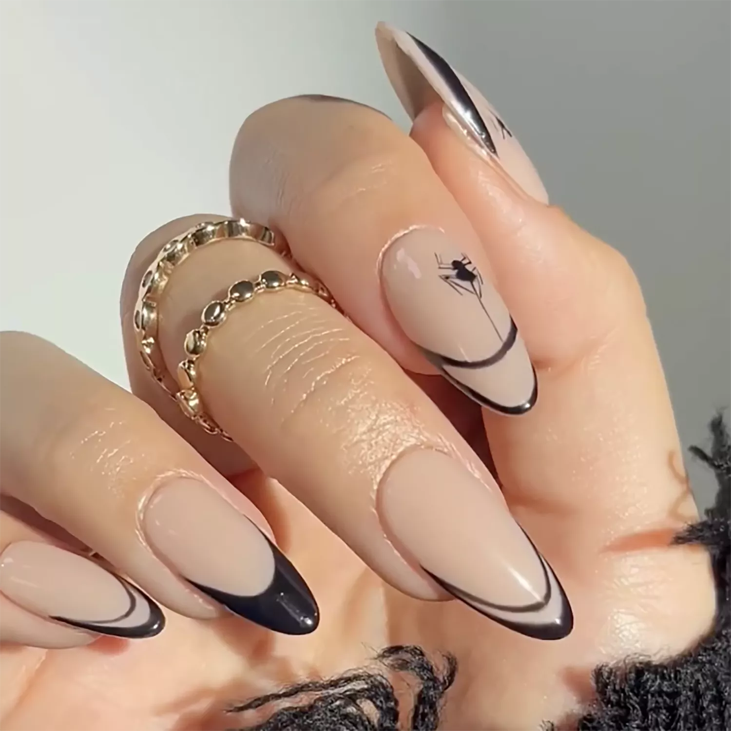 Close-up of orange, black, and white swirl French manicure with modern Halloween design.