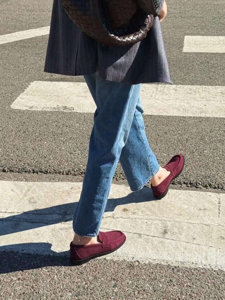 Burgundy leather loafers paired with cream trousers, showcasing the must-have shoe trend for fall outfits.