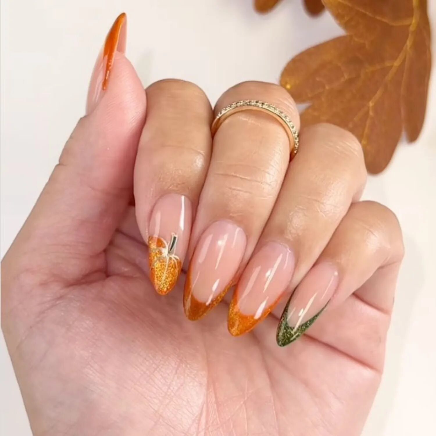 Velvet-finish French manicure in orange and green hues inspired by pumpkins and fall colors.