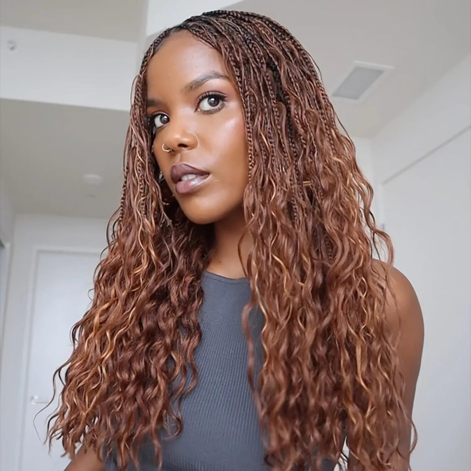 Woman with auburn braids wearing a cozy fall outfit, showcasing warm reddish-brown hair color.