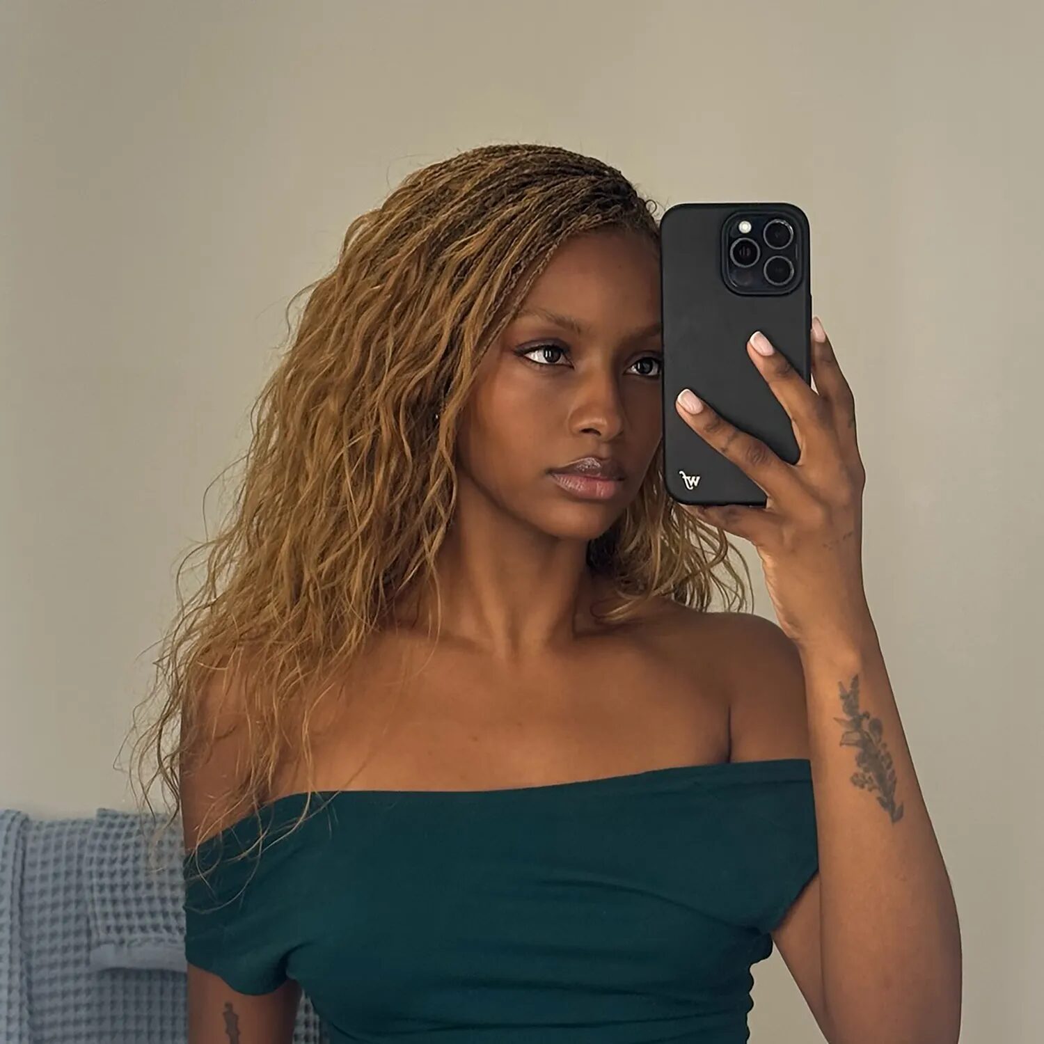 Close-up of honey blonde braids glistening under sunlight, styled in a sleek knotless braid look.