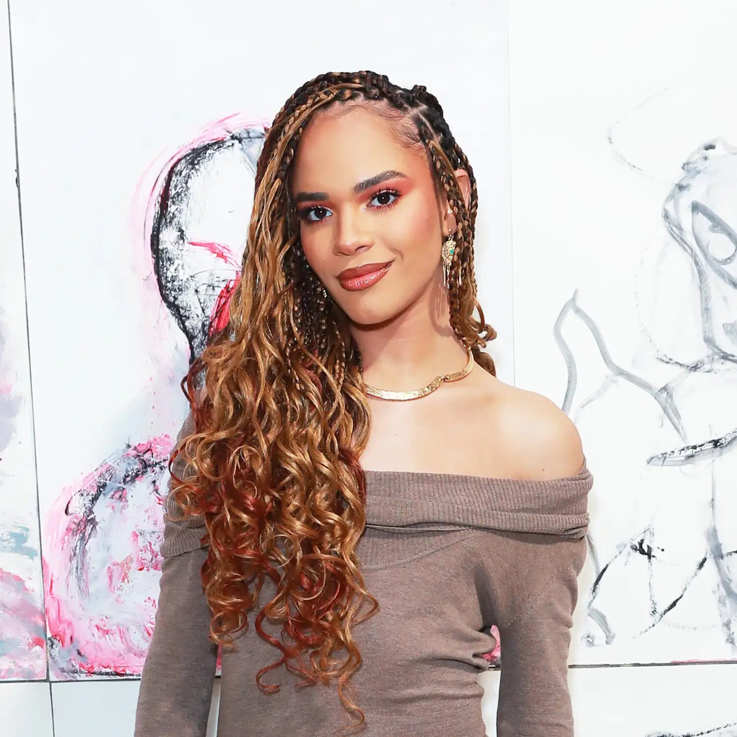 Woman with copper braids standing in golden-hour light, showing orange-red vibrance and warmth.