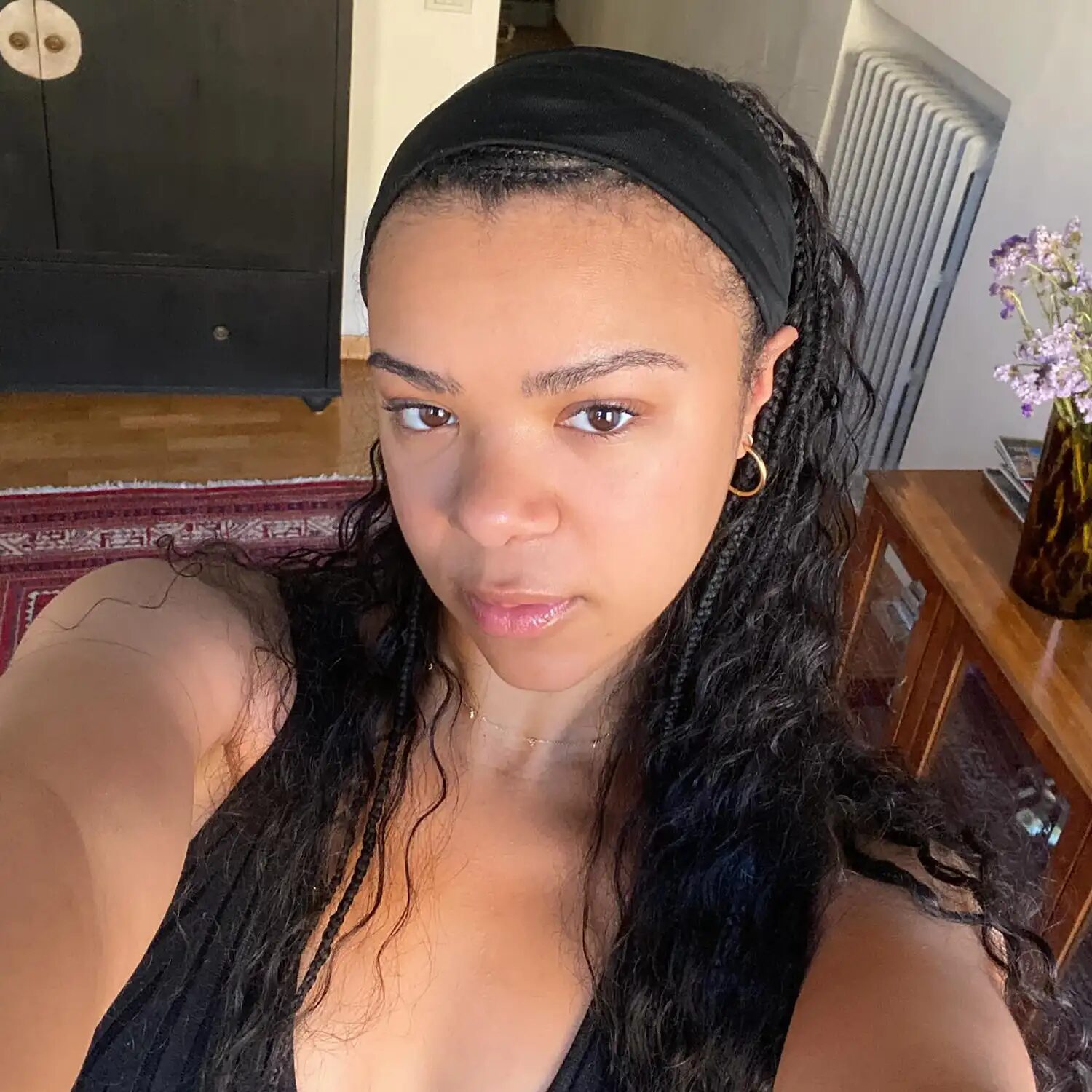 Model with dark brown braids styled in a chic updo, emphasizing soft black and brown dimension.