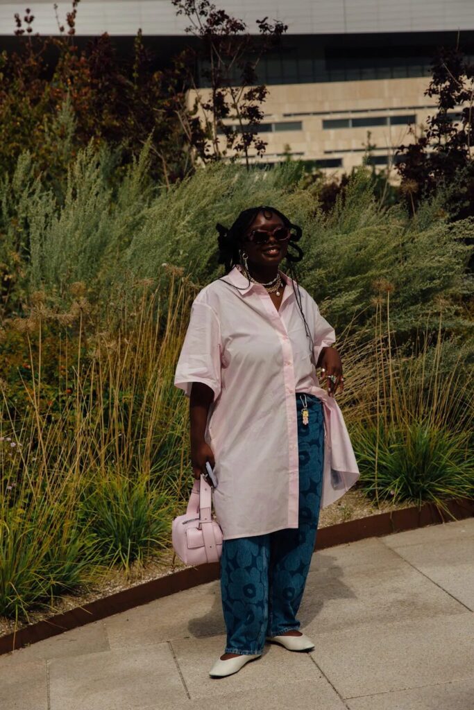Woman wearing a long white button-down shirt layered over jeans for a casual fall look.