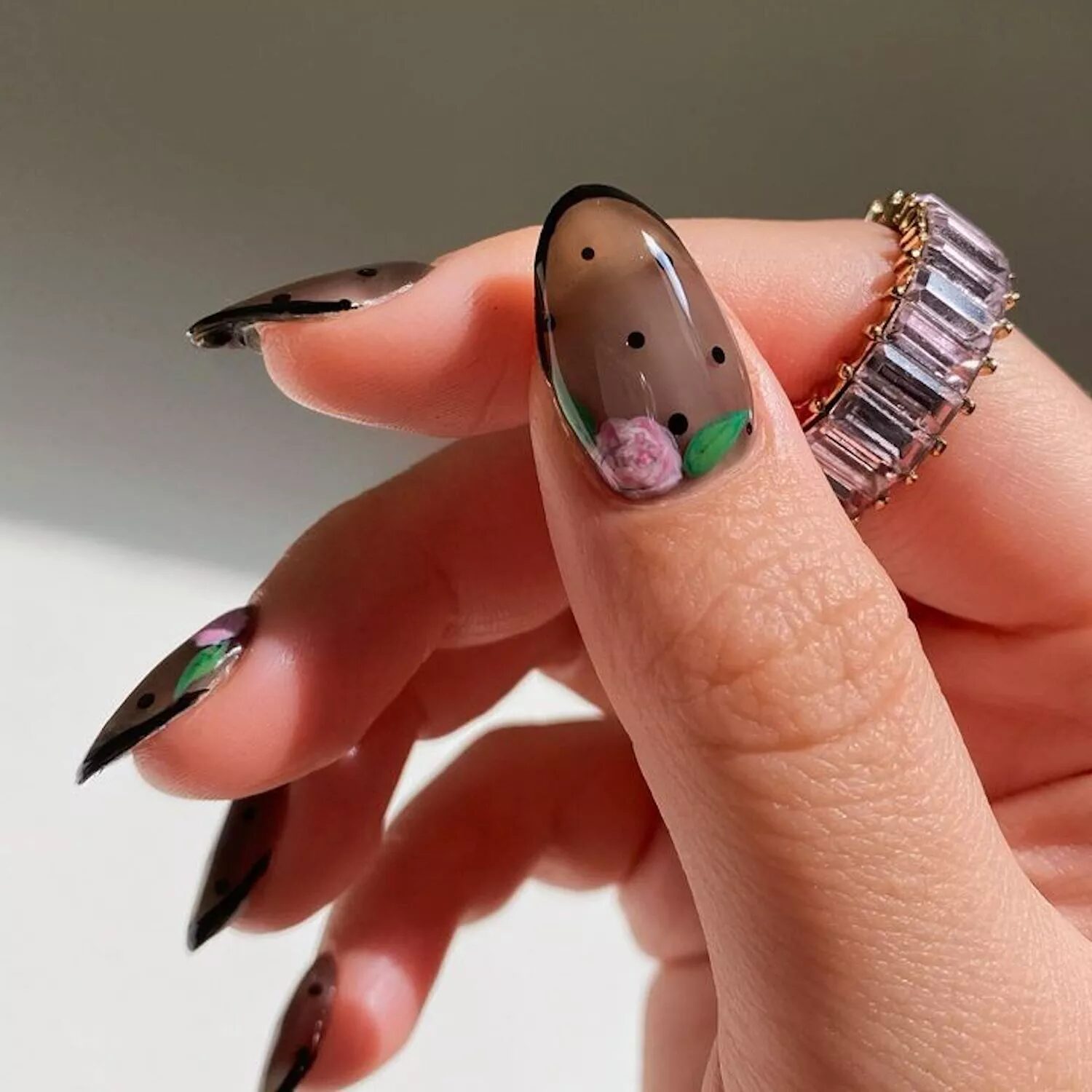 Sheer black manicure with French tips, roses, and gothic vampire-inspired nail art.